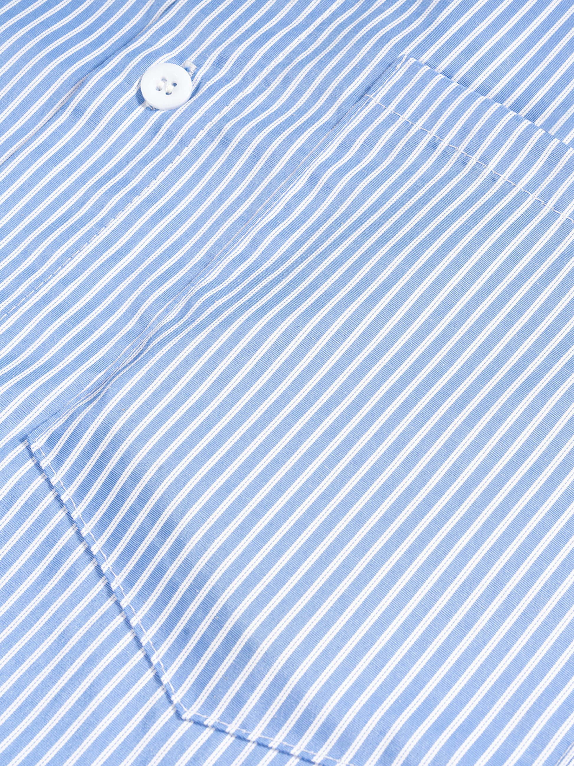 Close-up of a blue and white striped fabric with a button.