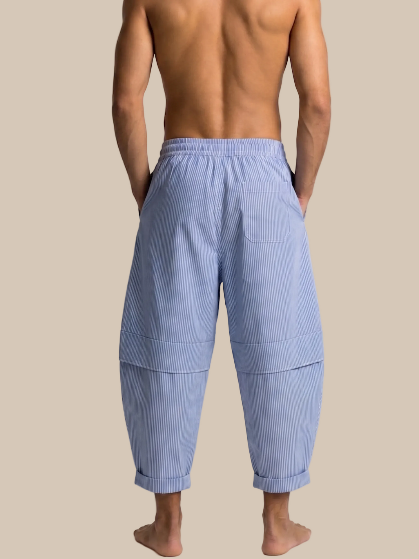 Man wearing light blue ribbed pants on a white background