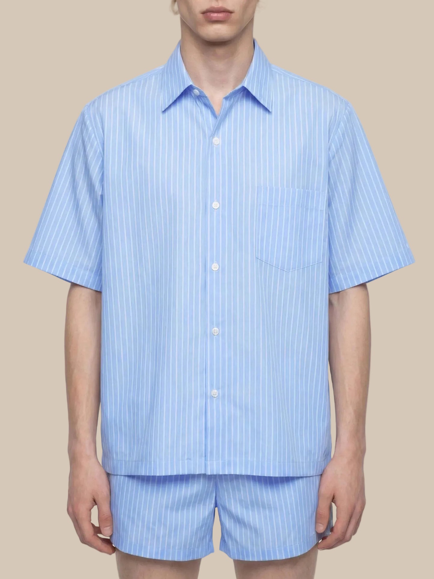Person wearing a light blue striped shirt and shorts set on a white background
