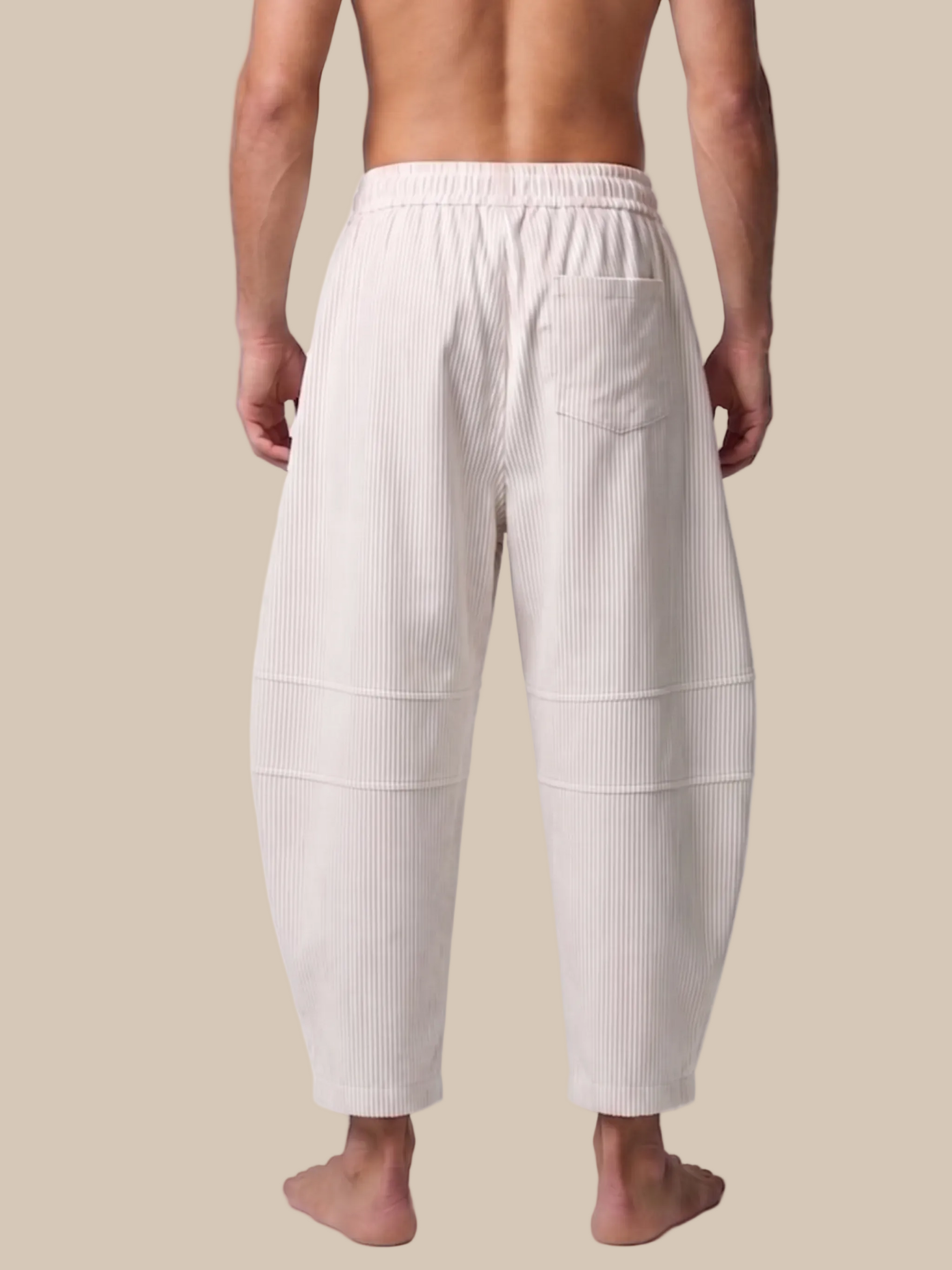 Person wearing white ribbed lounge pants on a plain background