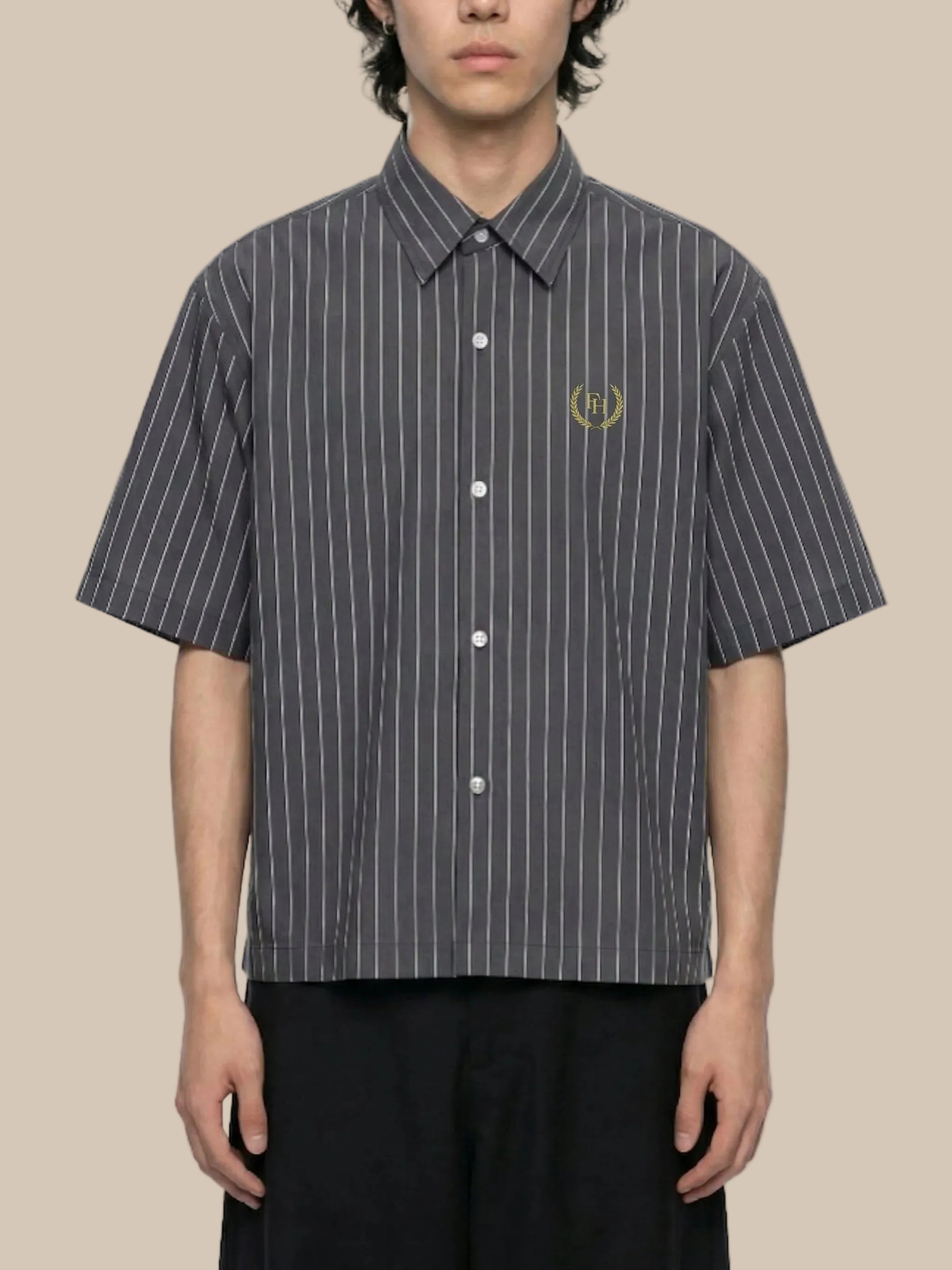 Person wearing a black and white striped shirt with a logo on a white background
