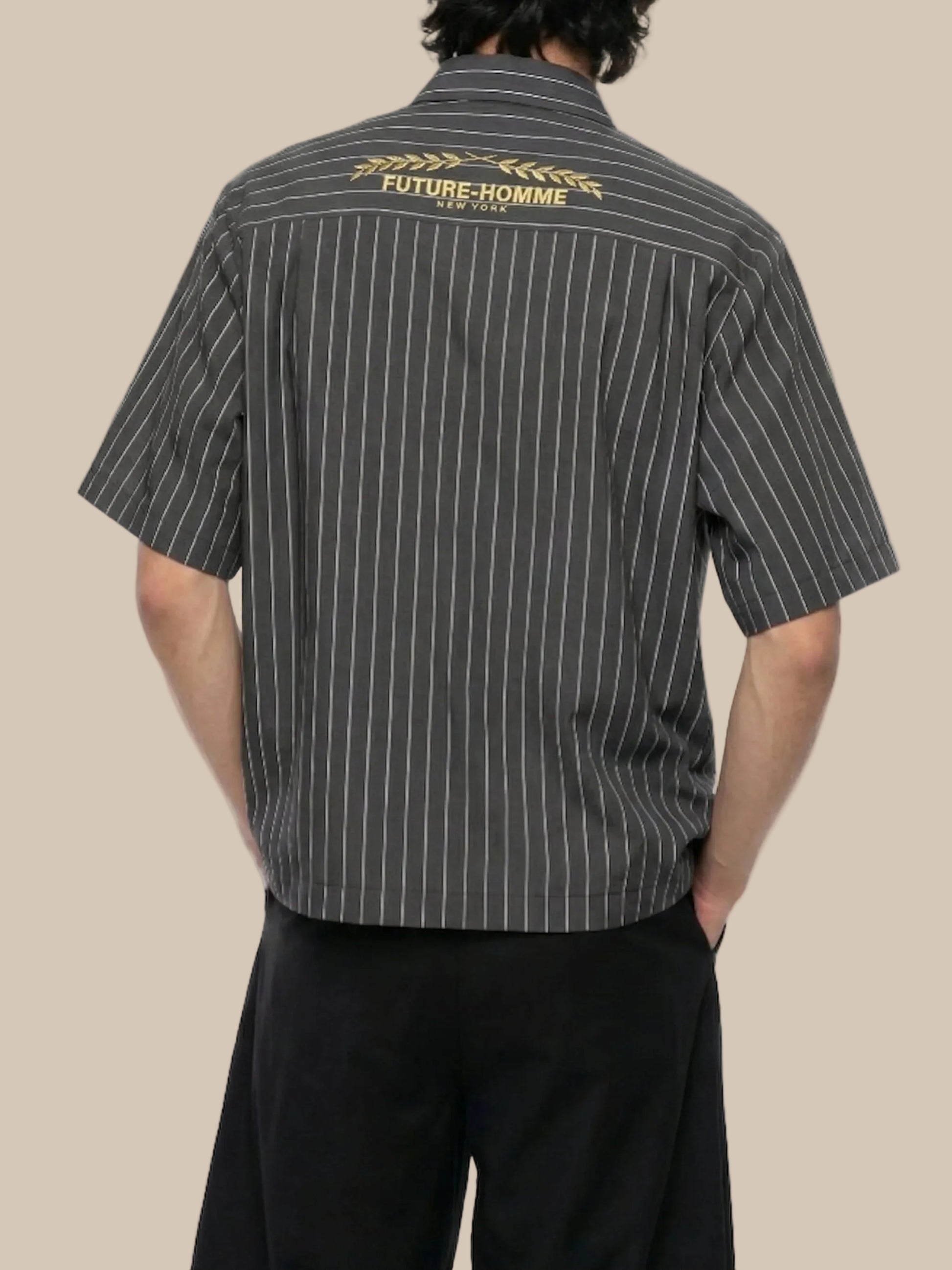 Person wearing a black pinstripe shirt with 'Future Homme' branding on the back.