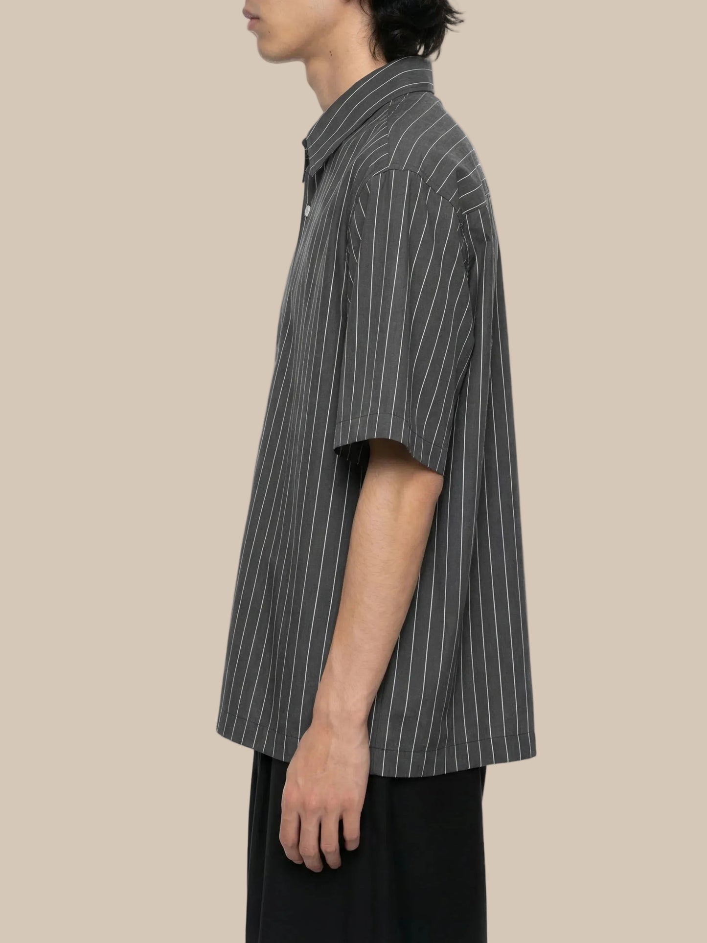 Person wearing a gray pinstripe shirt on a white background