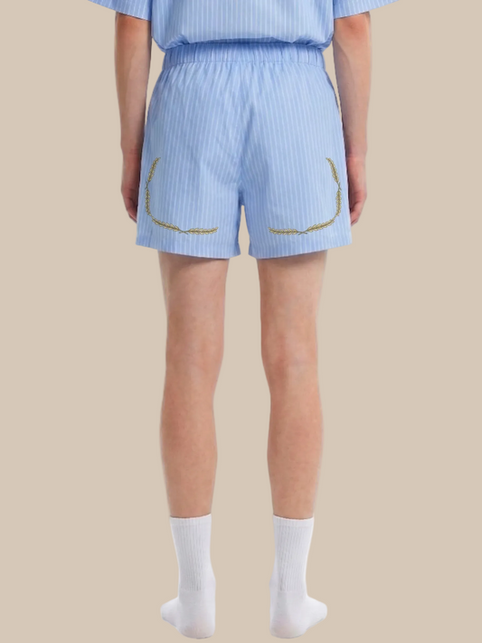 backside of a person wearing light blue pinstripe shorts with a laurel trim on a white background