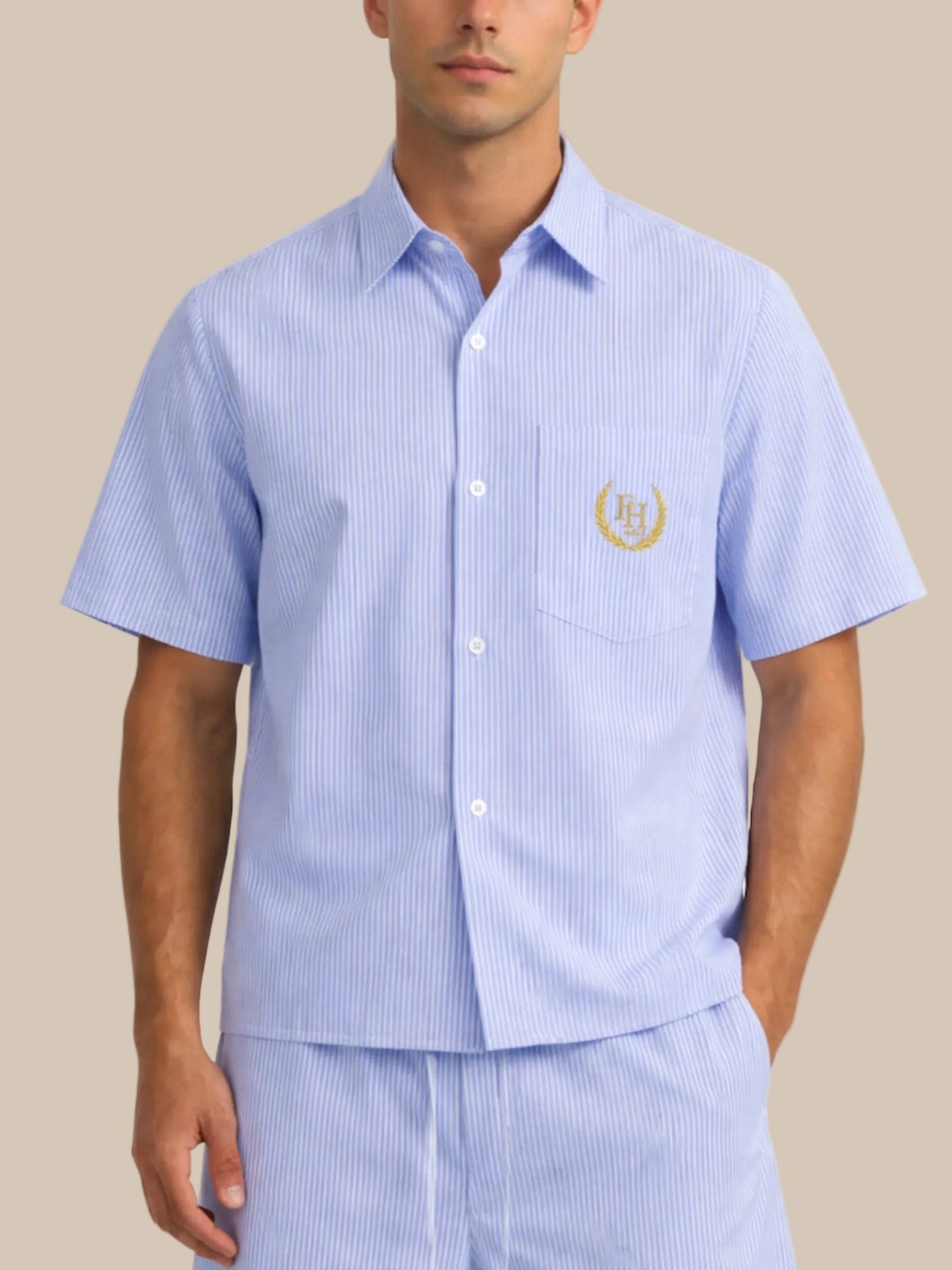 Man wearing a light blue striped pajama set with a logo on a white background