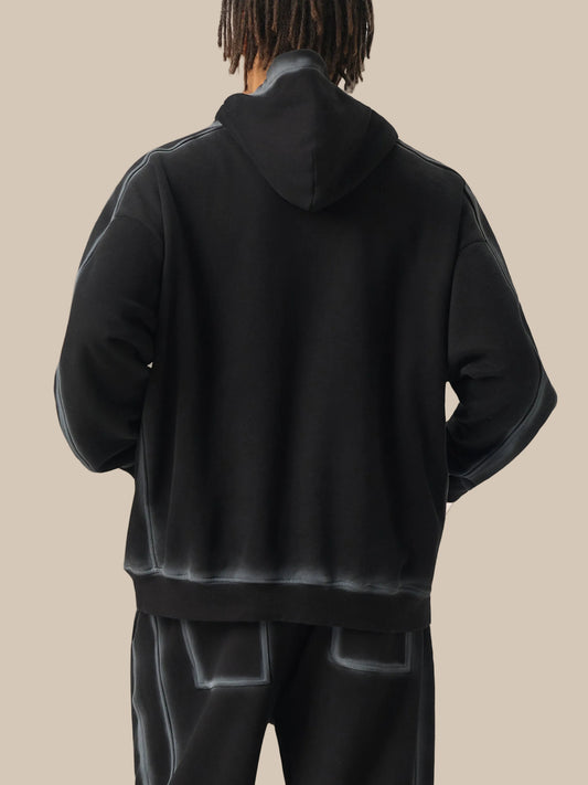 Person wearing a black hoodie and pants on a white background
