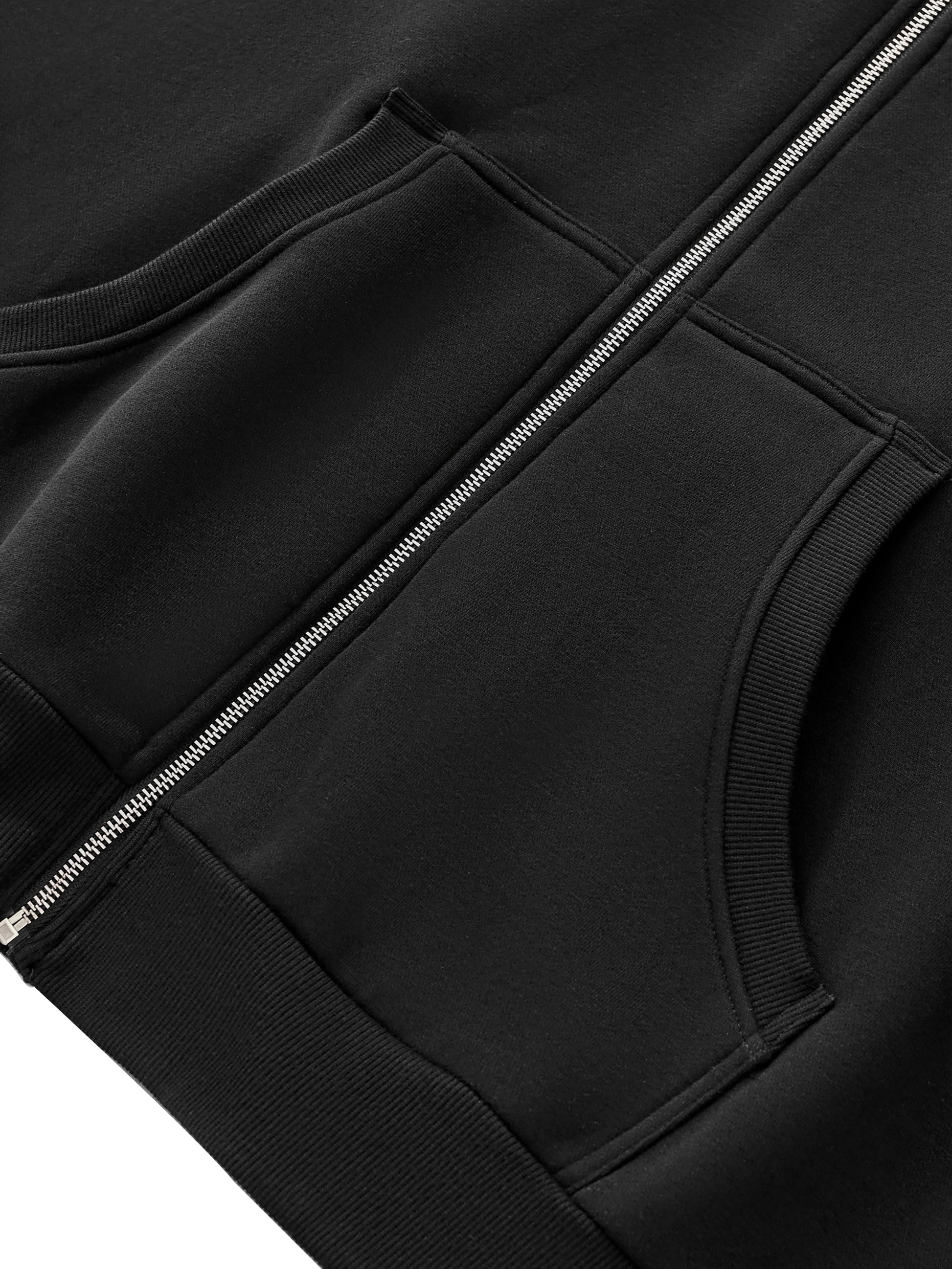 A Future-Homme Fleece Please Close-up of a black jacket with a zipper and pockets on a white background.