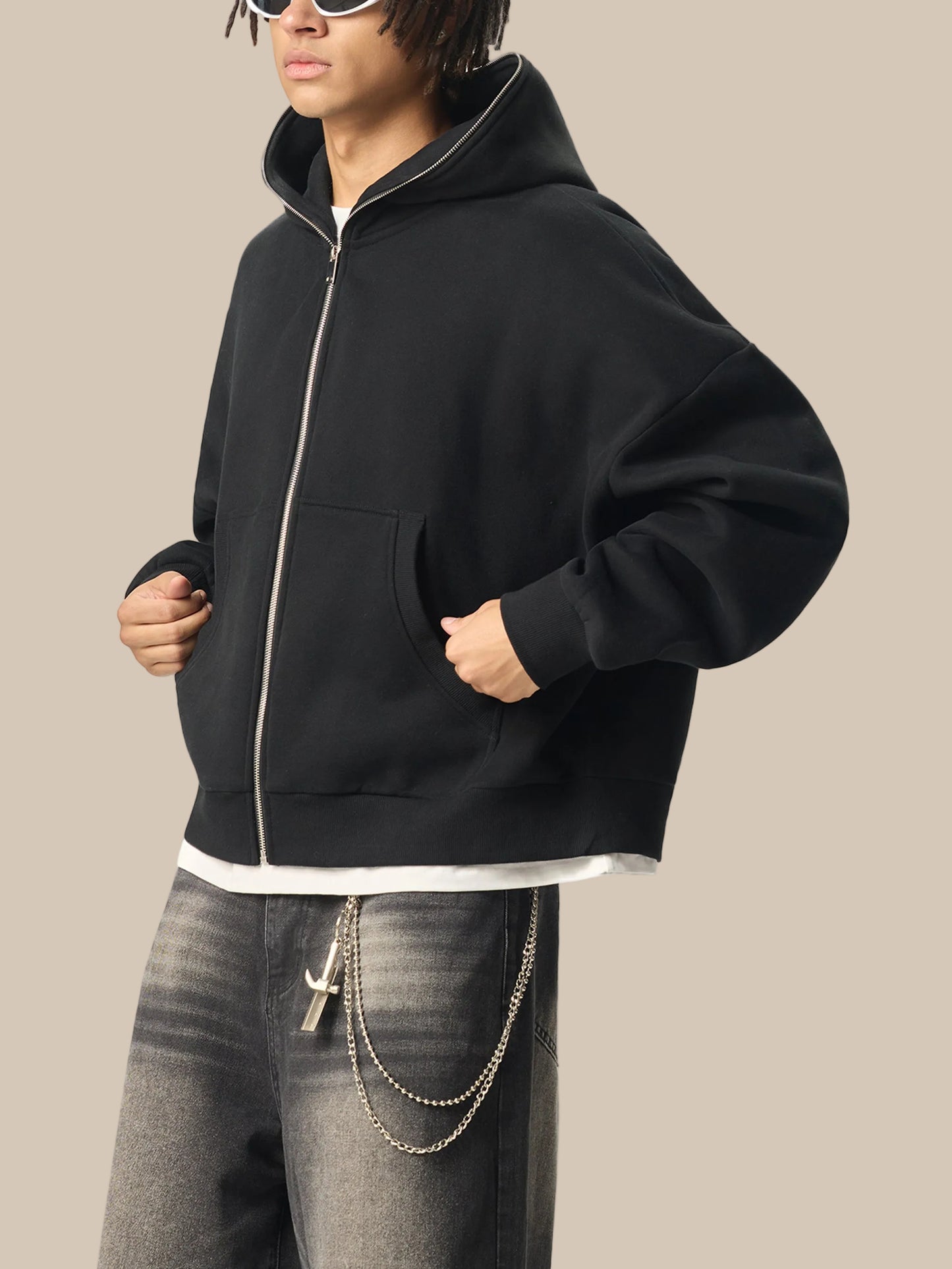 Person wearing a black future-homme hoodie with a white zipper on a white background