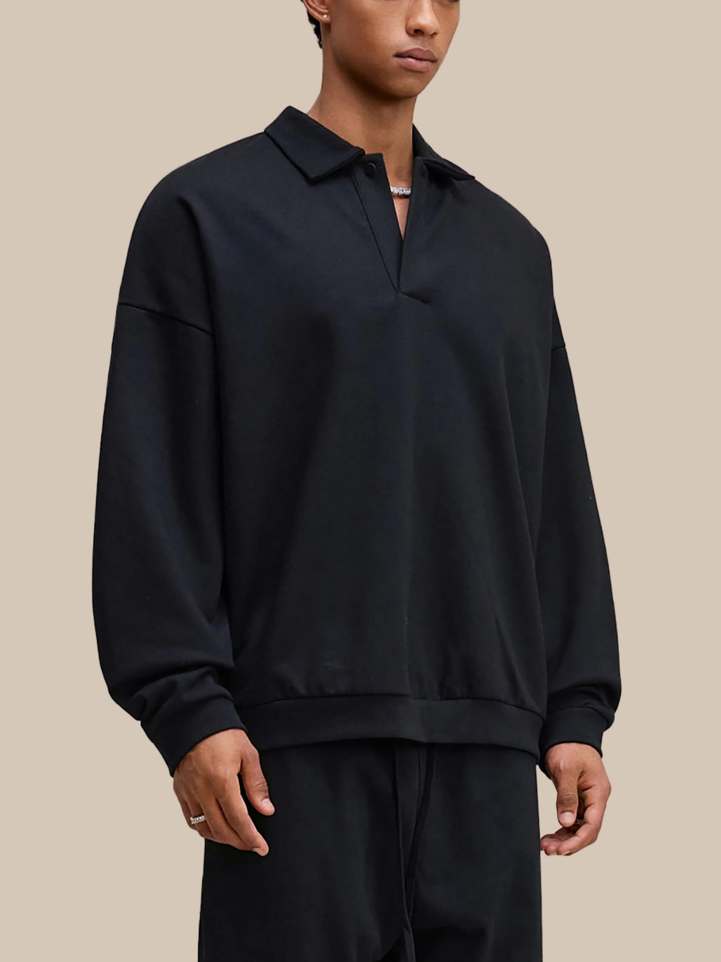 Person wearing a black pullover with a collar on a white background