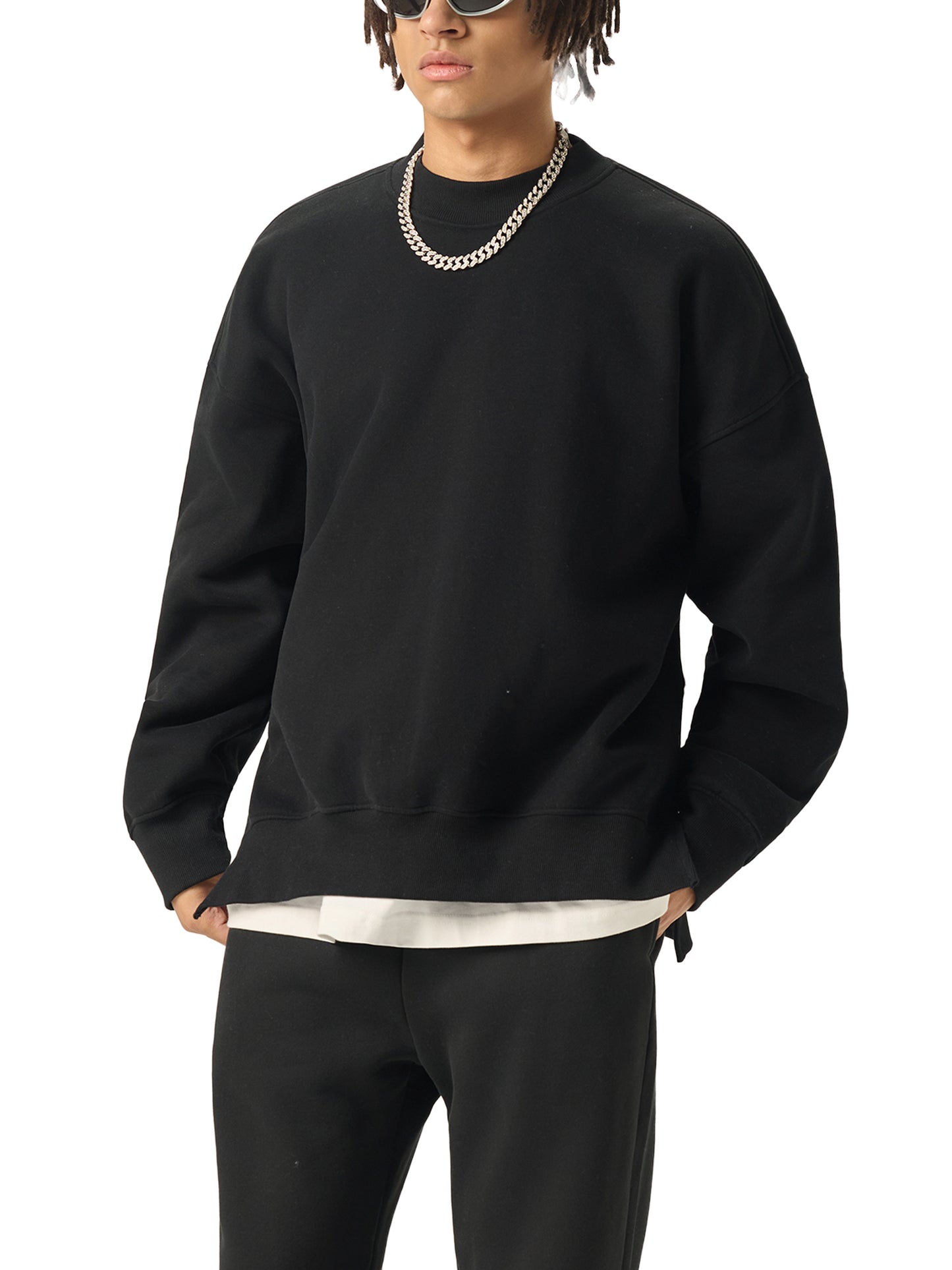 Future-Homme model wearing a black side slit Fleece Please sweatshirt and pants with a white shirt underneath on a white background. 