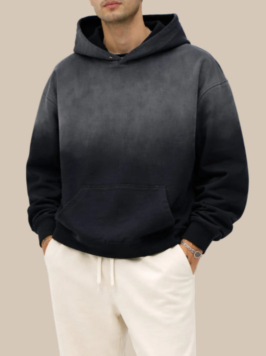 Person wearing a black hoodie and light-colored pants on a white background