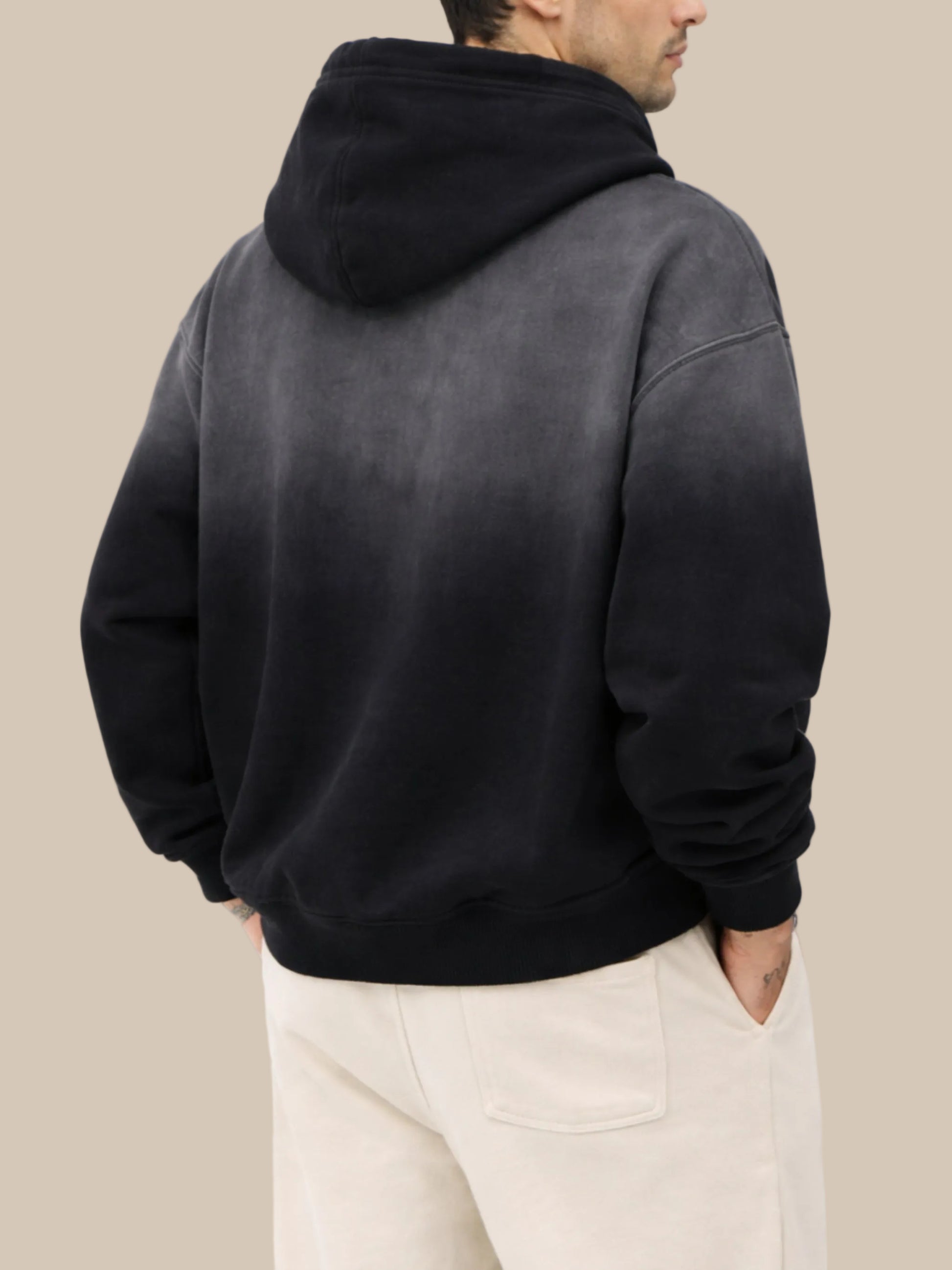 Person wearing a black hoodie from behind on a white background