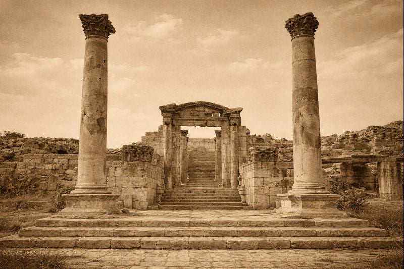 Ancient ruins with columns and steps under a cloudy sky