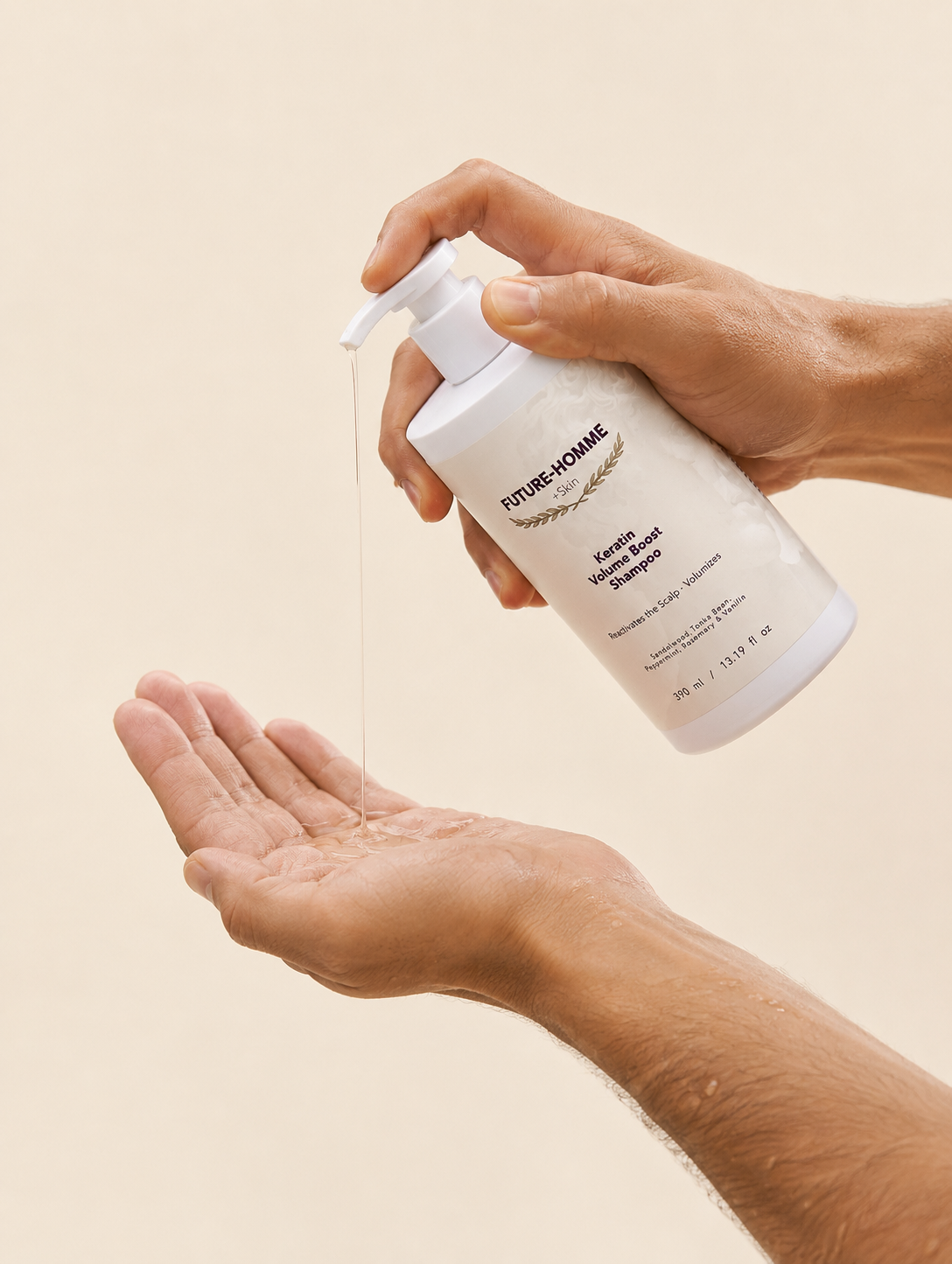 Hand holding a white bottle labeled 'FUTURE-HOMME' with a pump, dispensing liquid onto another hand against a beige background.