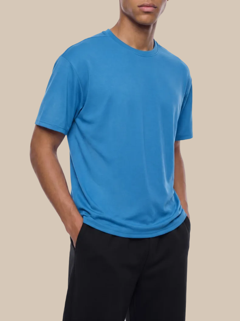Person wearing a blue t-shirt and black pants on a white background