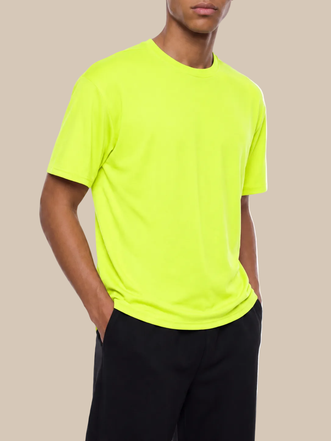 A person wearing a bright green performance t-shirt on a beige background. 