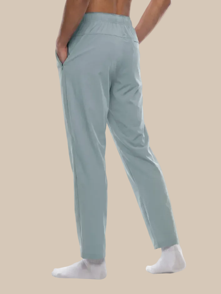Gray blue track pants worn by a person on a beige background