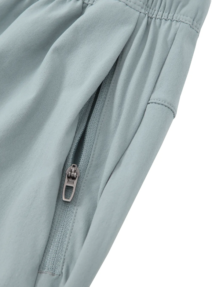 Close-up of a light gray pants with a zipper on a white background