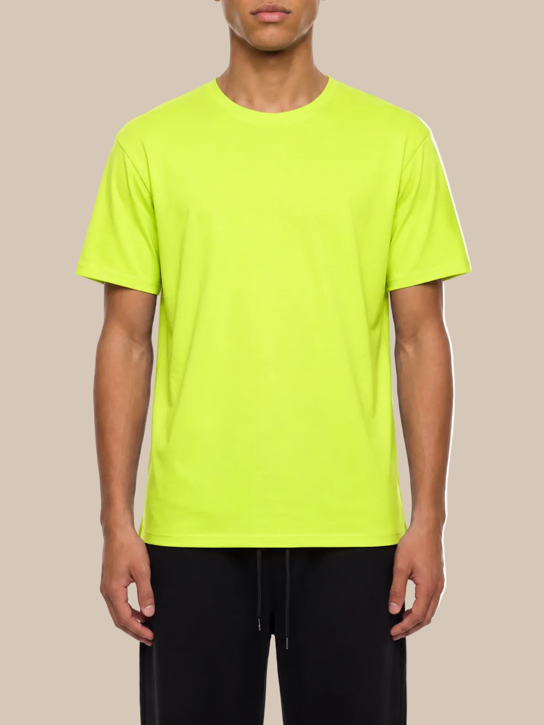 A person wearing a bright neon green performance t-shirt on a beige background. 