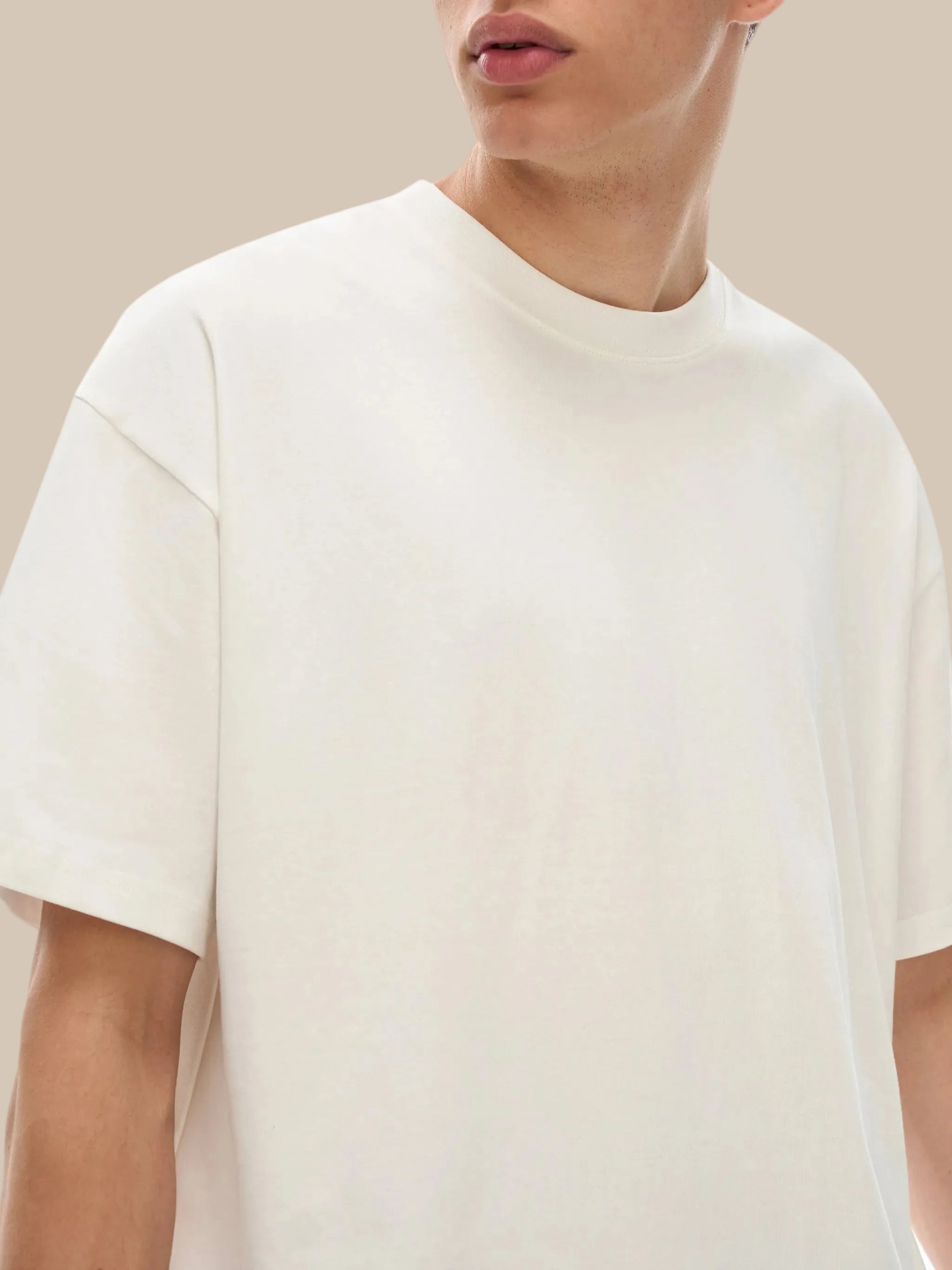 Person wearing a plain white t-shirt against a white background