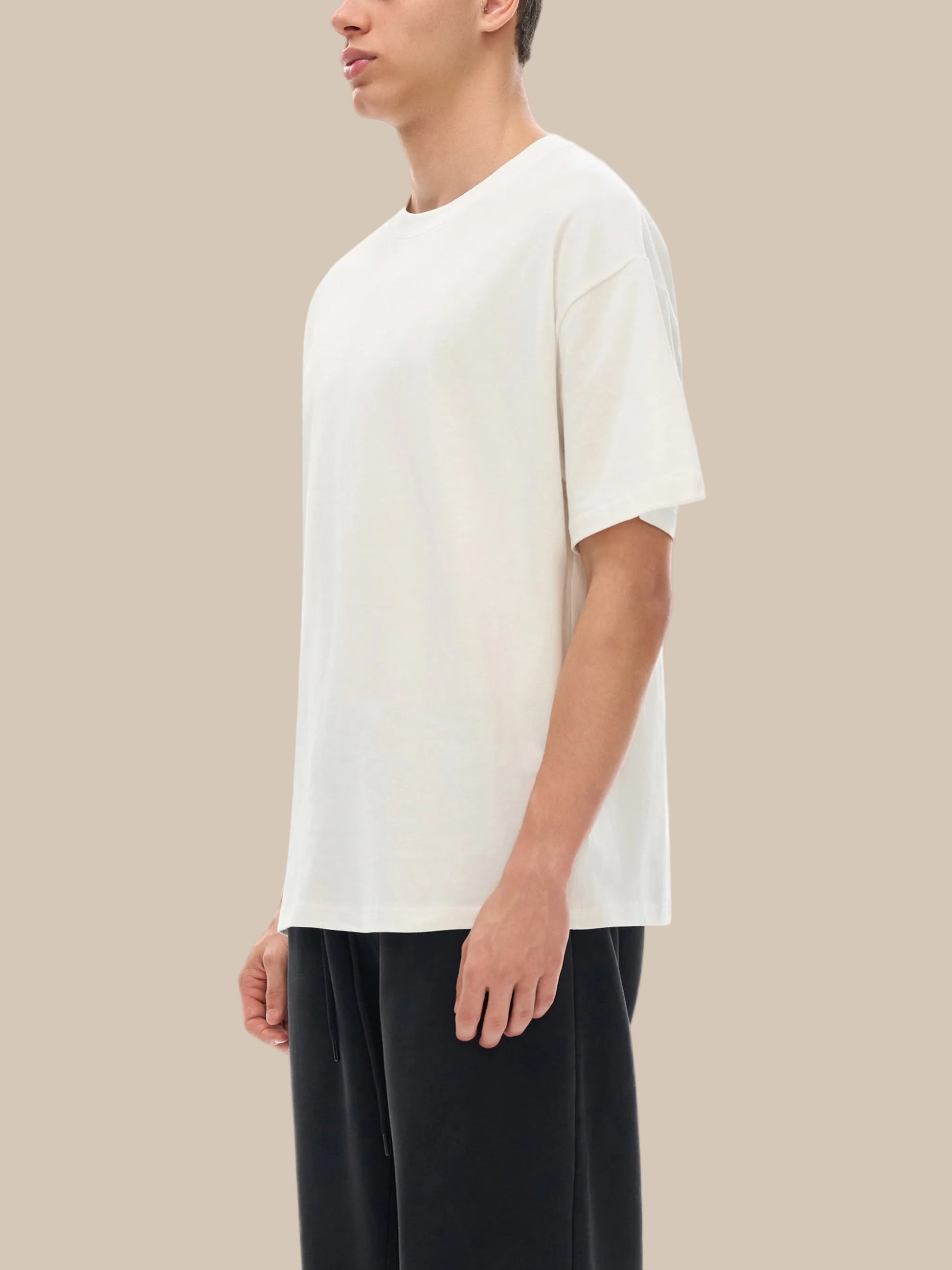 Person wearing a white t-shirt and black pants on a white background