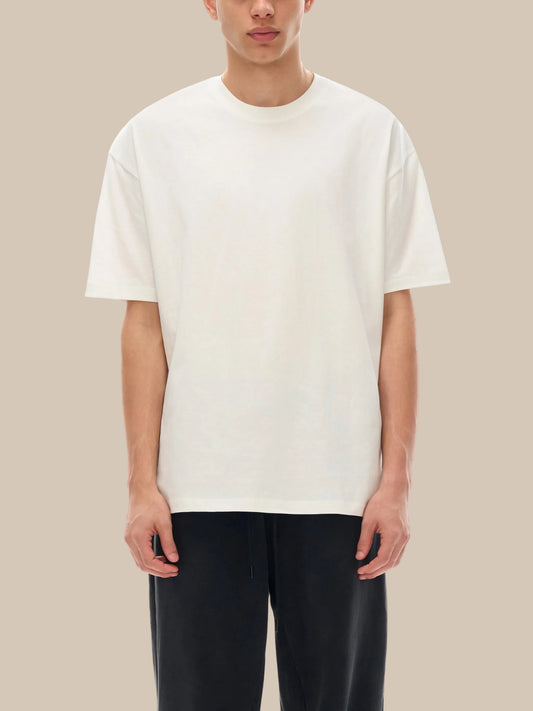 Person wearing a plain white t-shirt and black pants on a white background