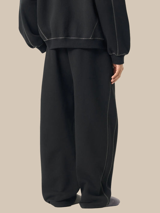 Person wearing a black outfit with wide-leg pants on a white background