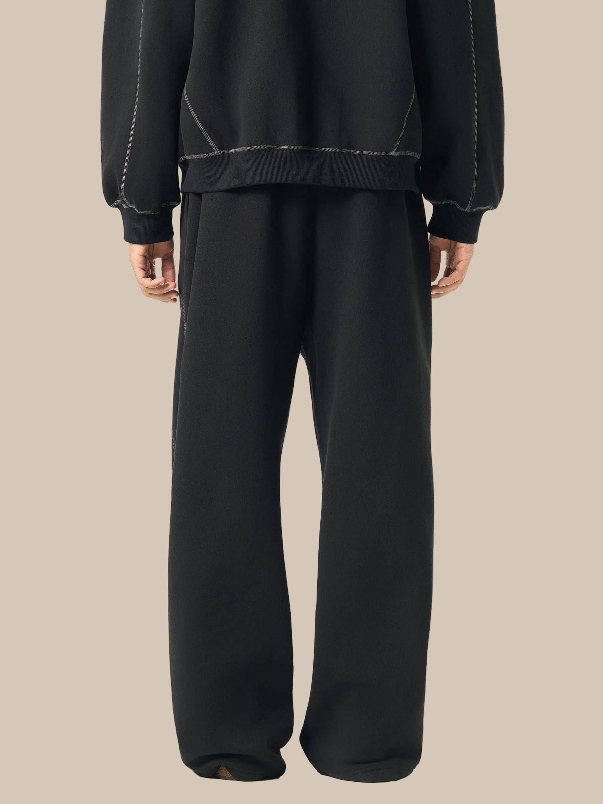 Black outfit with a sweater and wide-leg pants on a white background