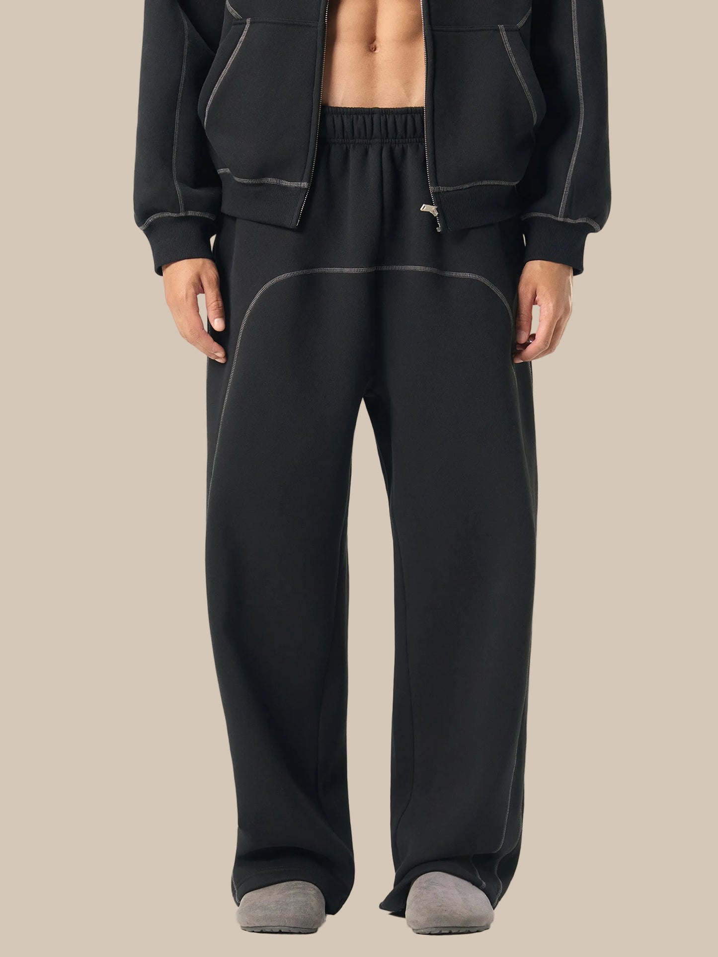 Person wearing black tracksuit on a white background