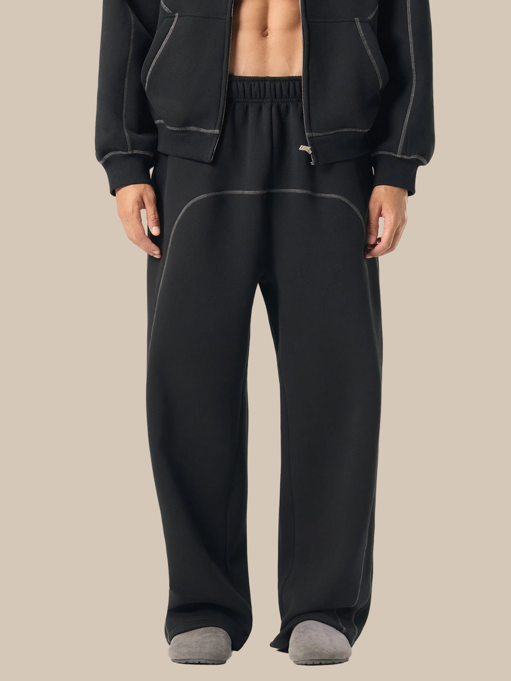 Person wearing black tracksuit on a white background