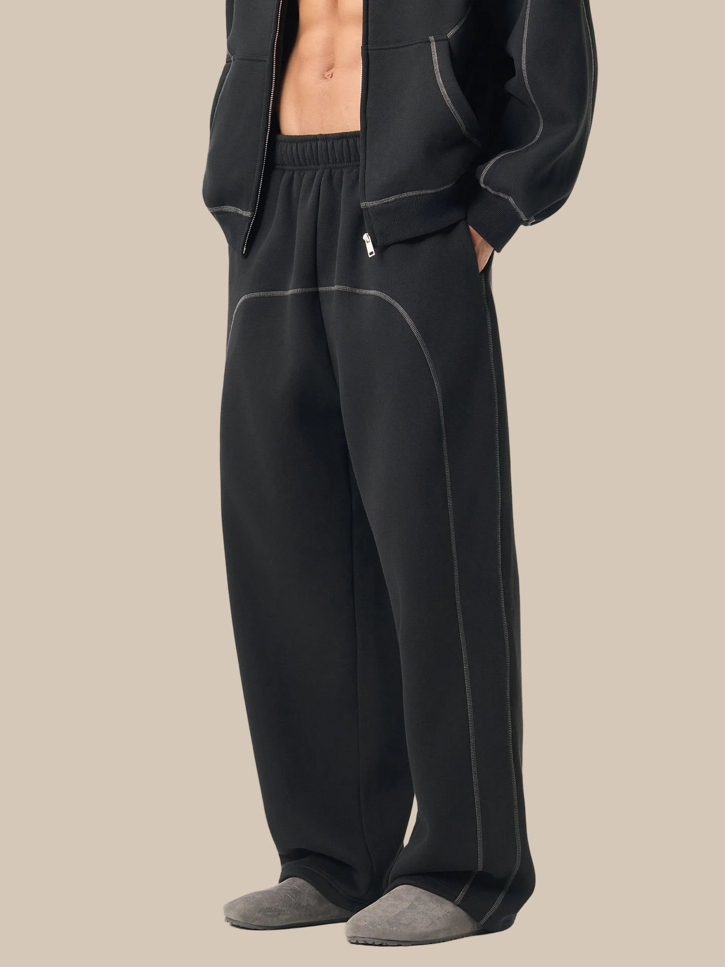 Person wearing black pajama pants with a white background