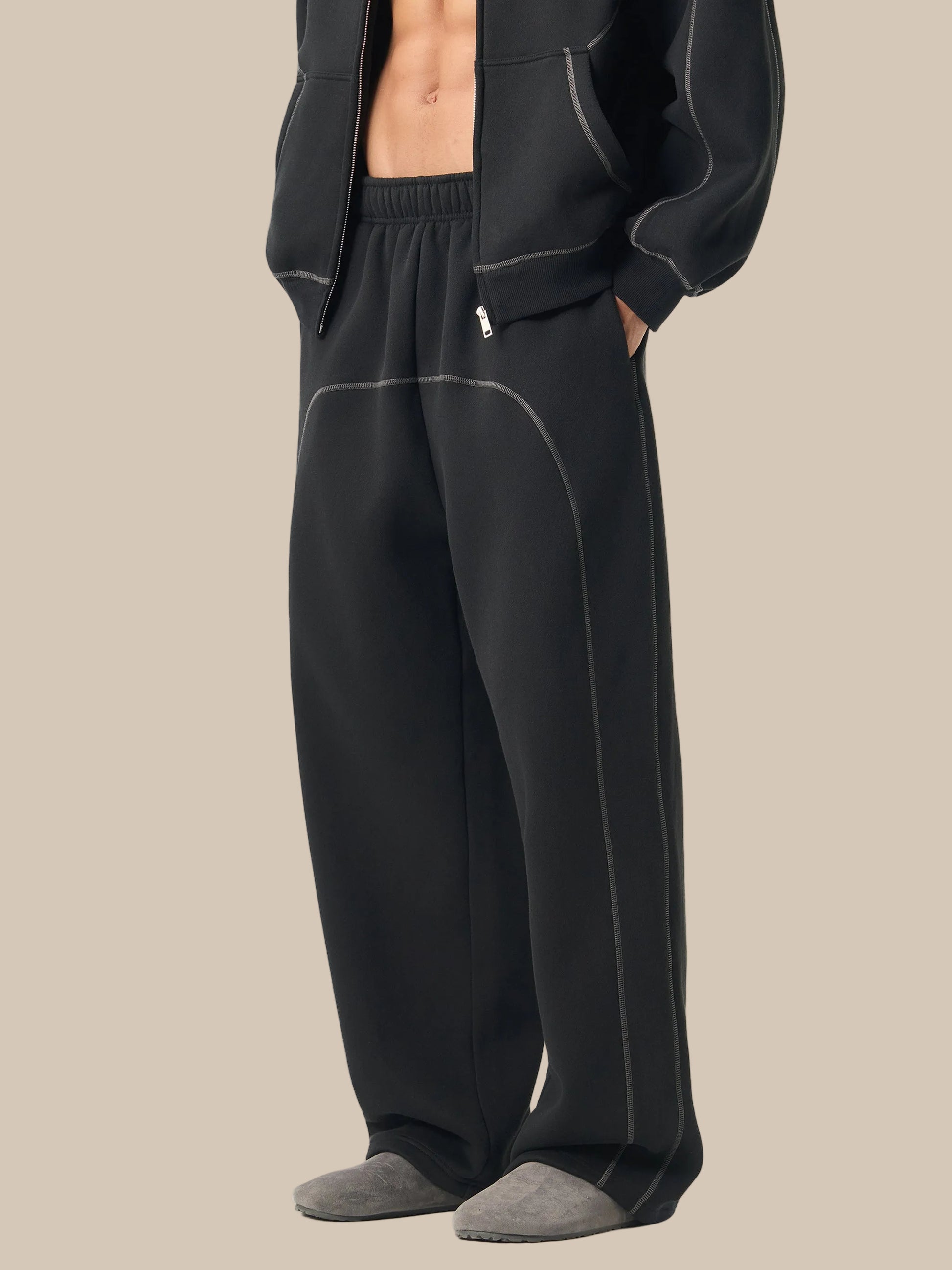 Person wearing black pajama pants with a white background