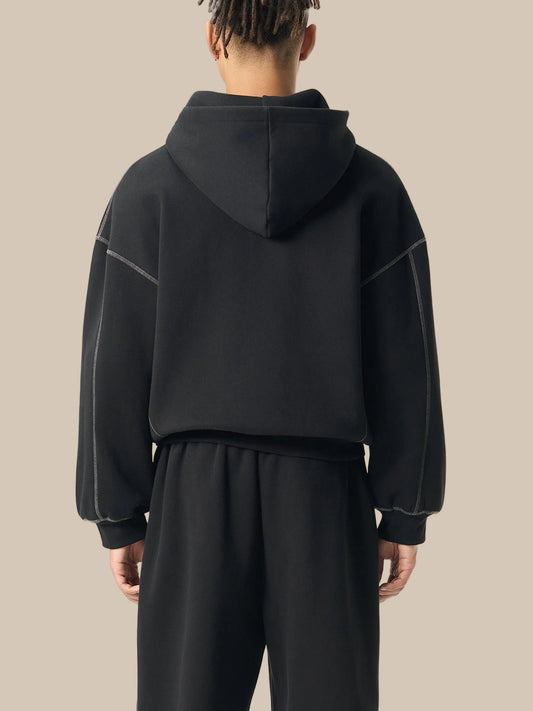 Person wearing a black hoodie and pants backside on a white background