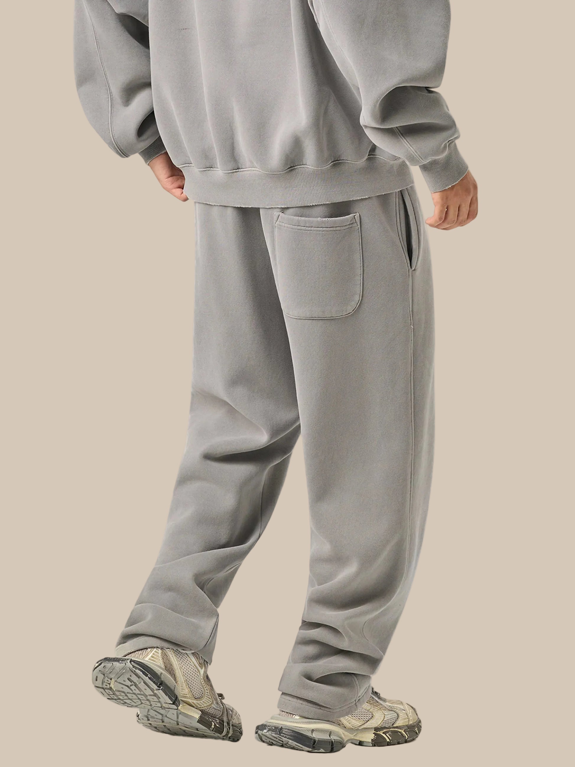 Person wearing a gray tracksuit on a white background