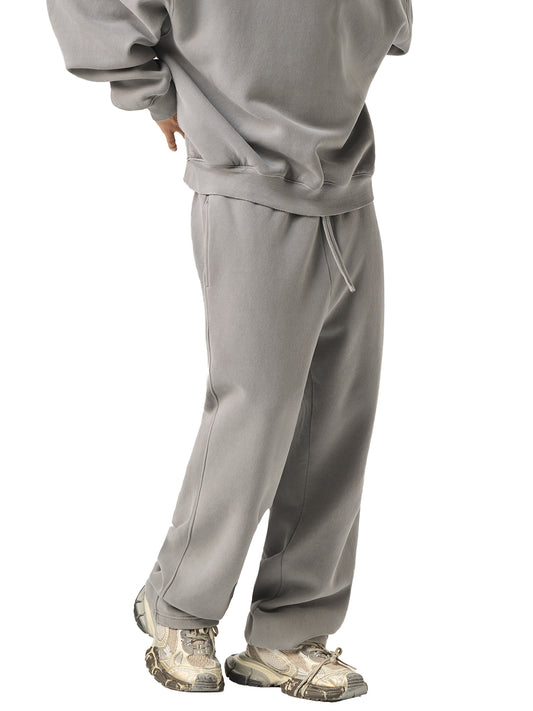 Person wearing a gray tracksuit with camouflage shoes on a white background