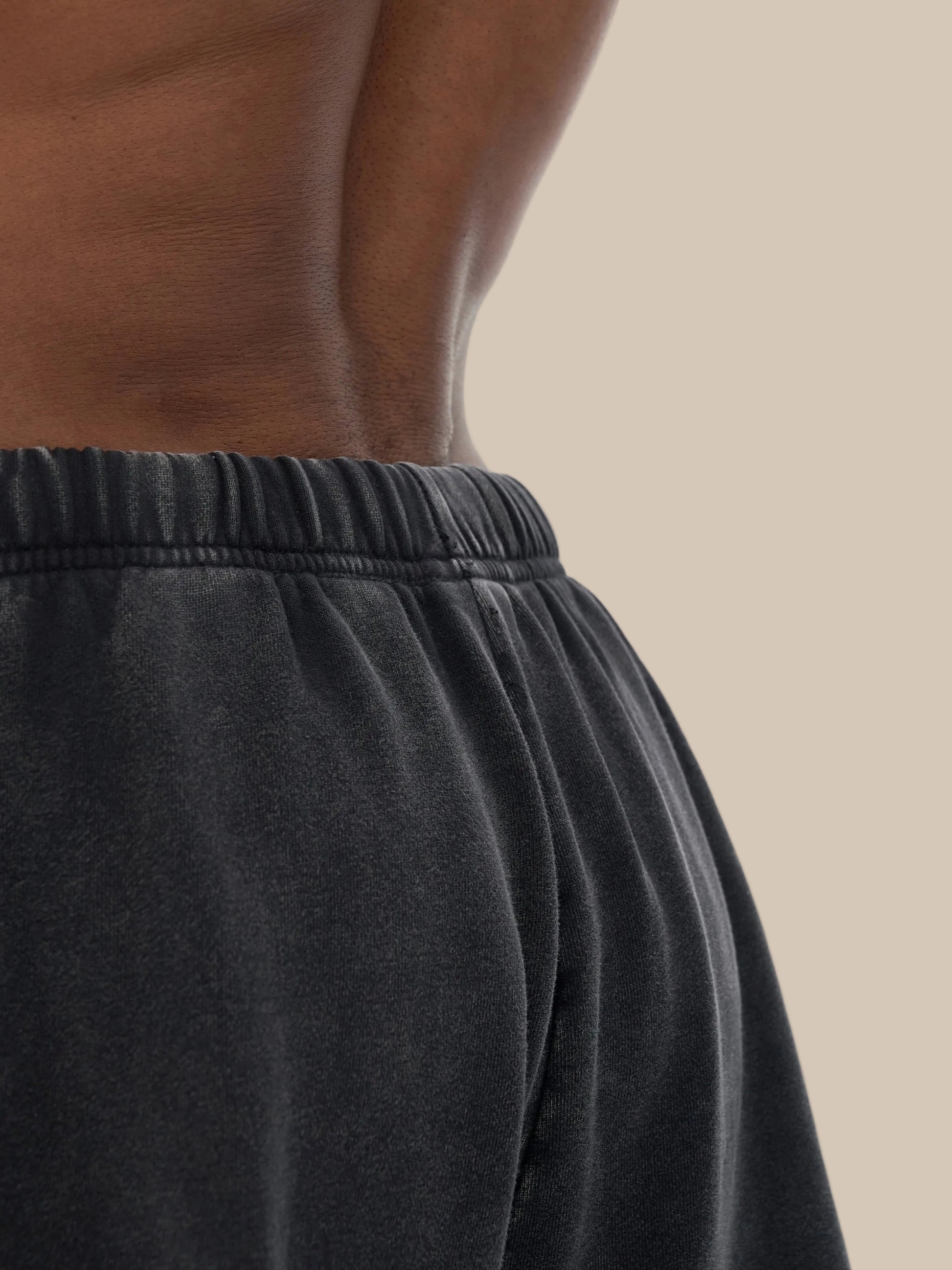 Close-up of a person wearing black shorts on a white background