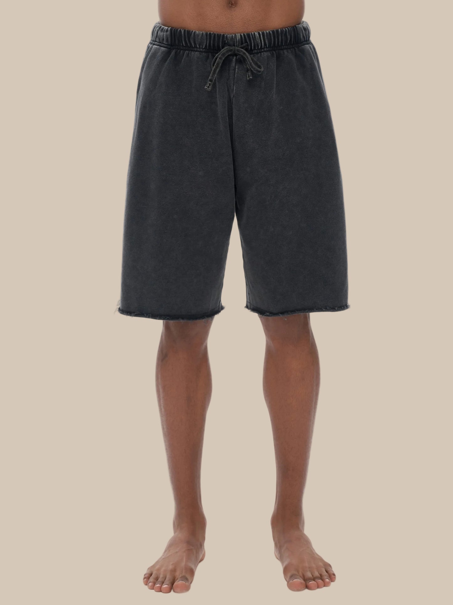 model wearing black acid wash future-homme shorts on a beige background 