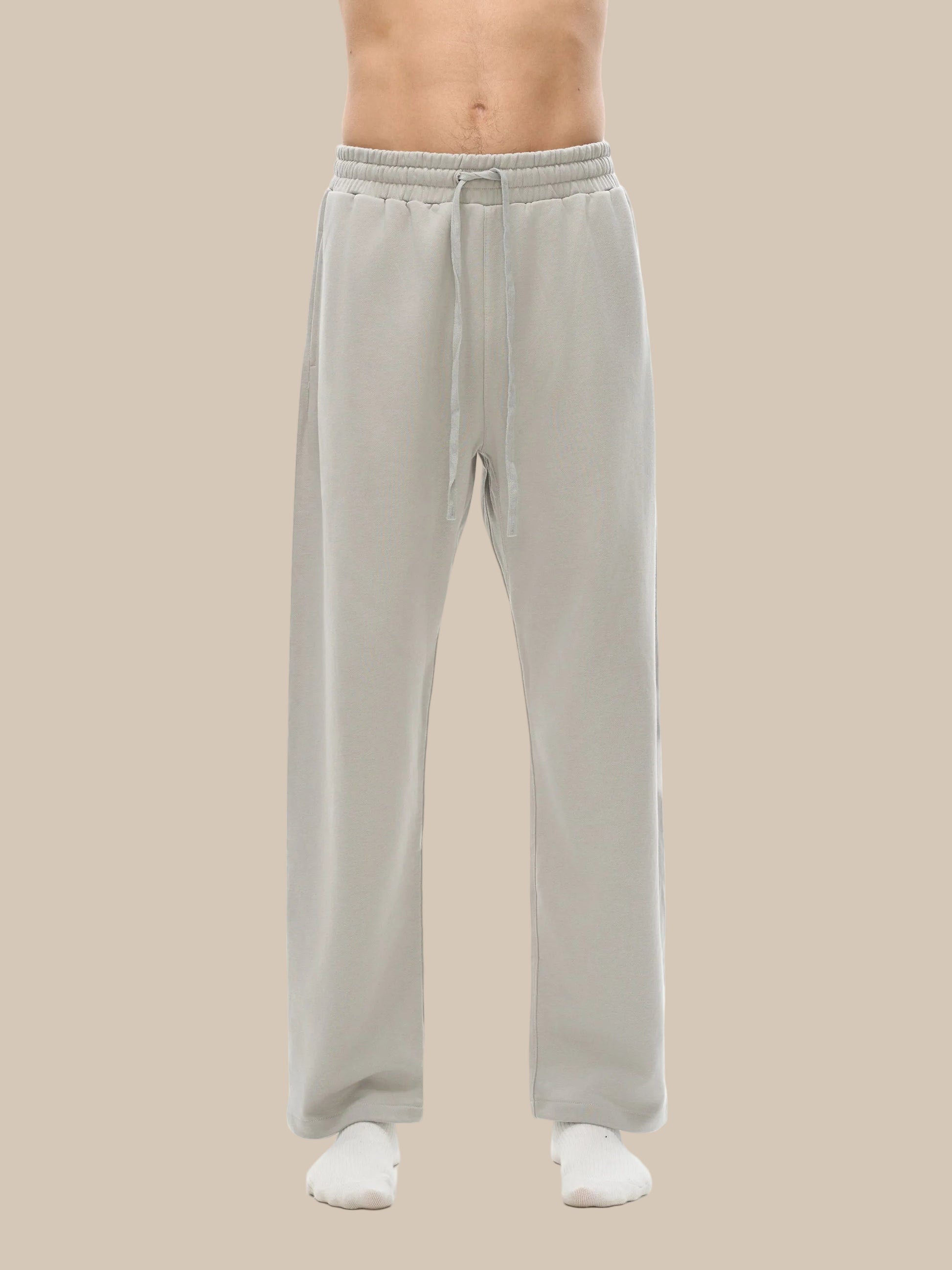 Light gray sweatpants worn by a person on a white background