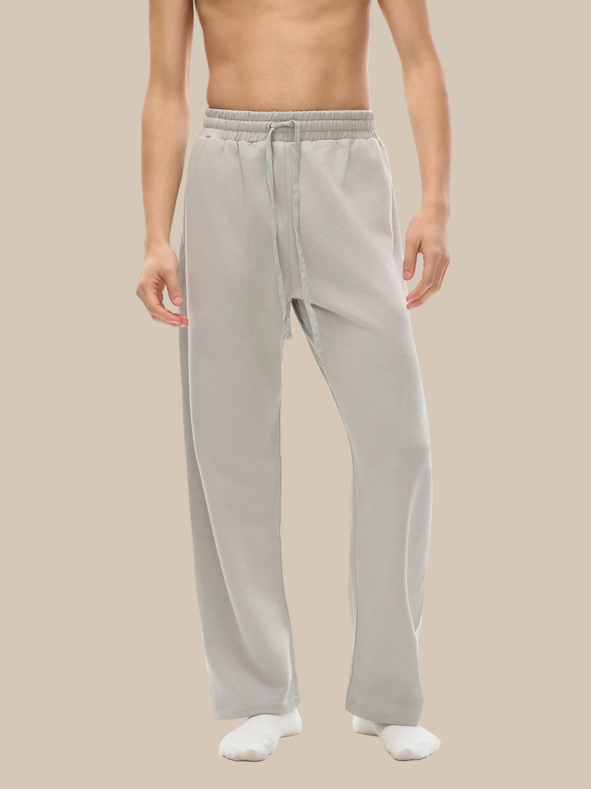 Person wearing light gray pants on a white background