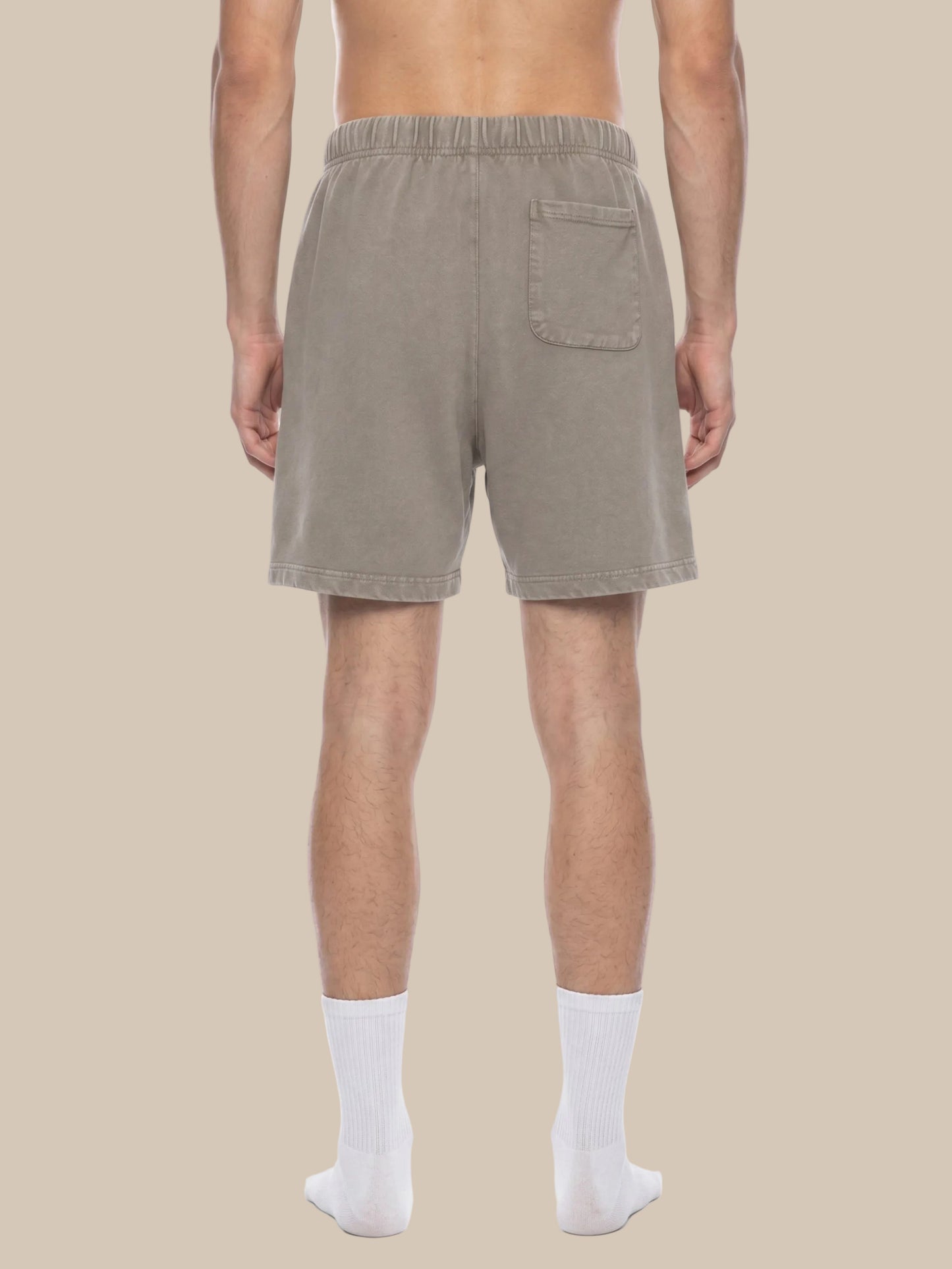 Man wearing beige shorts on a white background