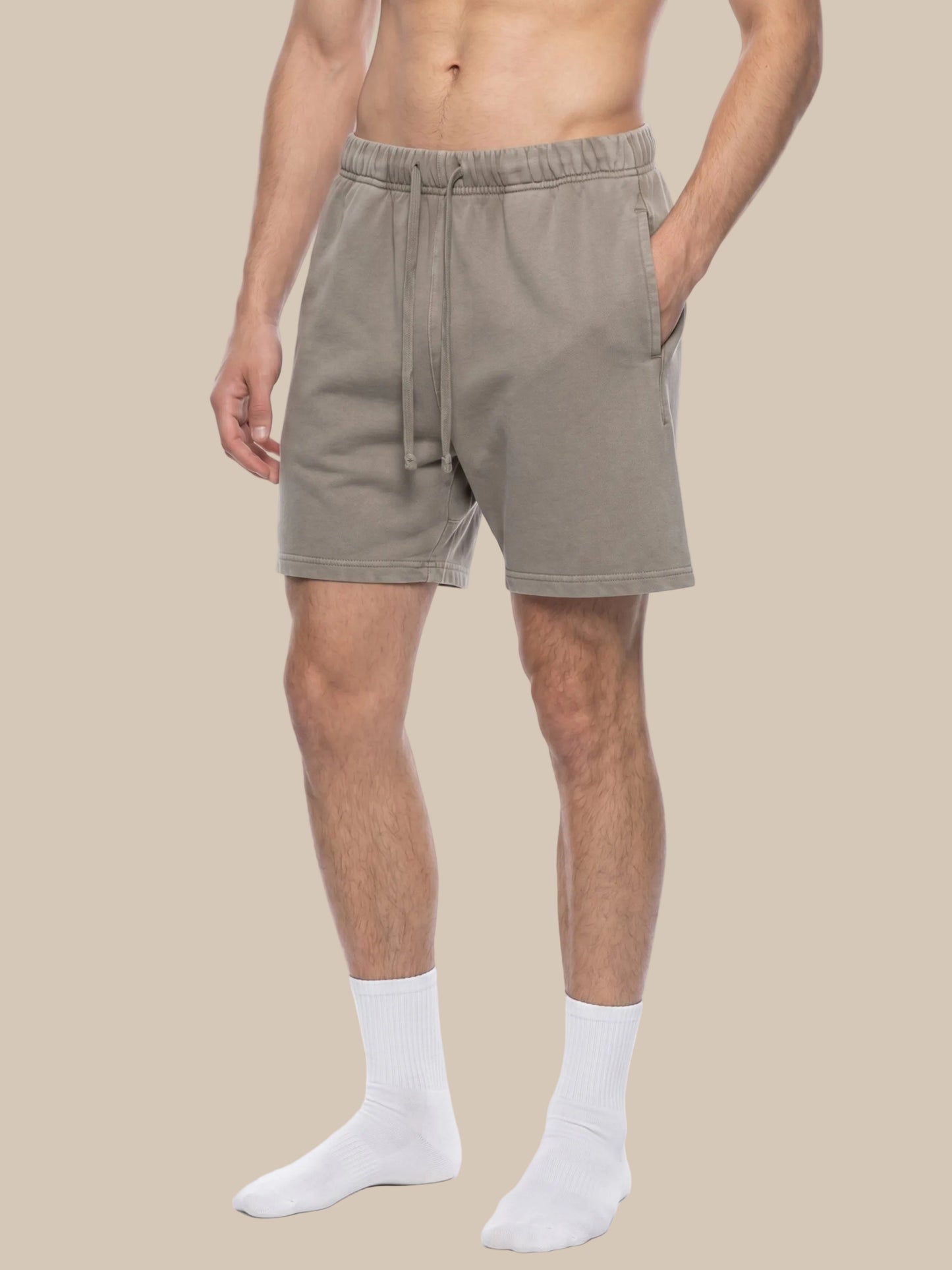 Man wearing beige future-homme vintage wash shorts on a beige background