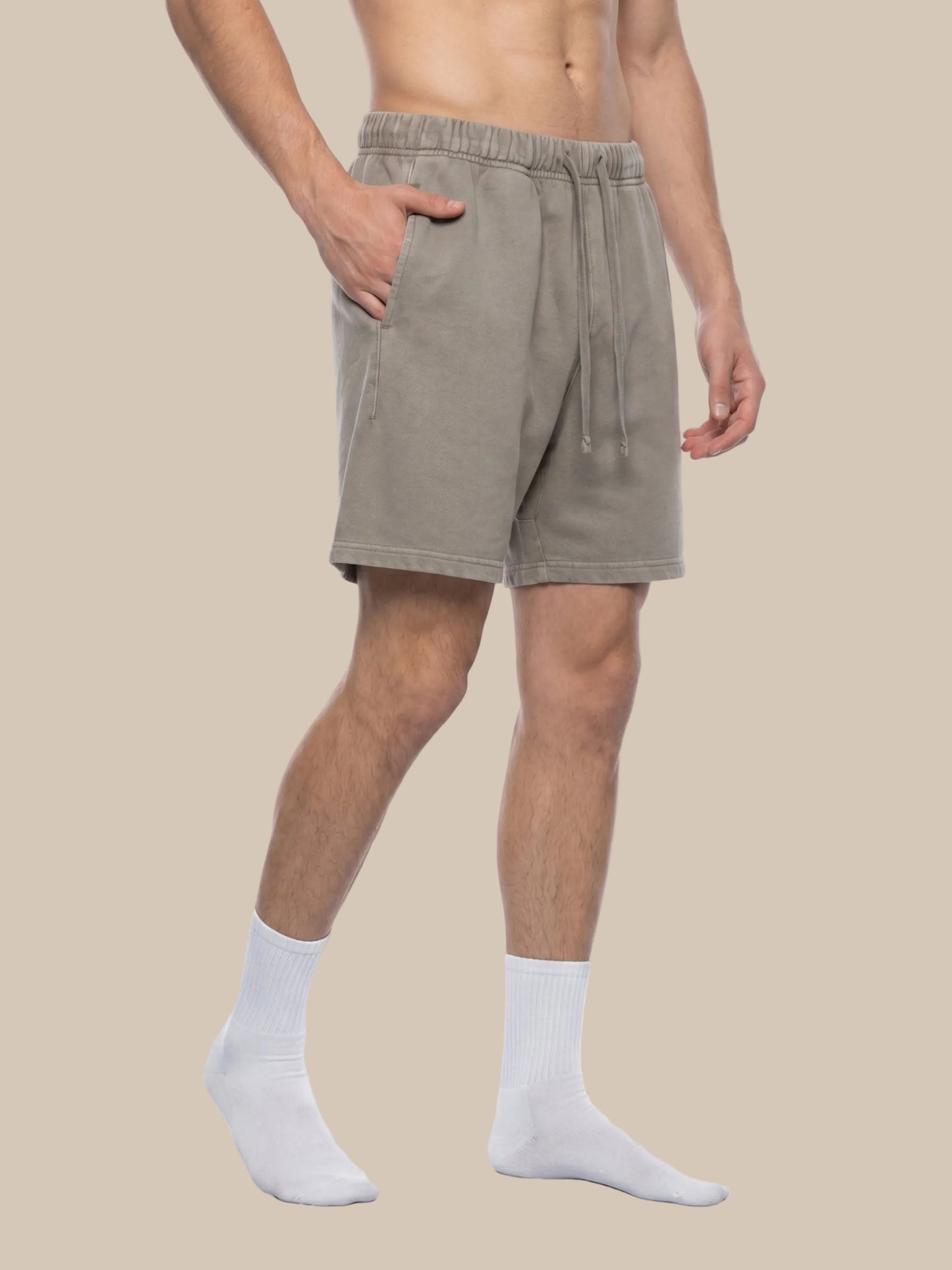 Person wearing beige shorts on a white background