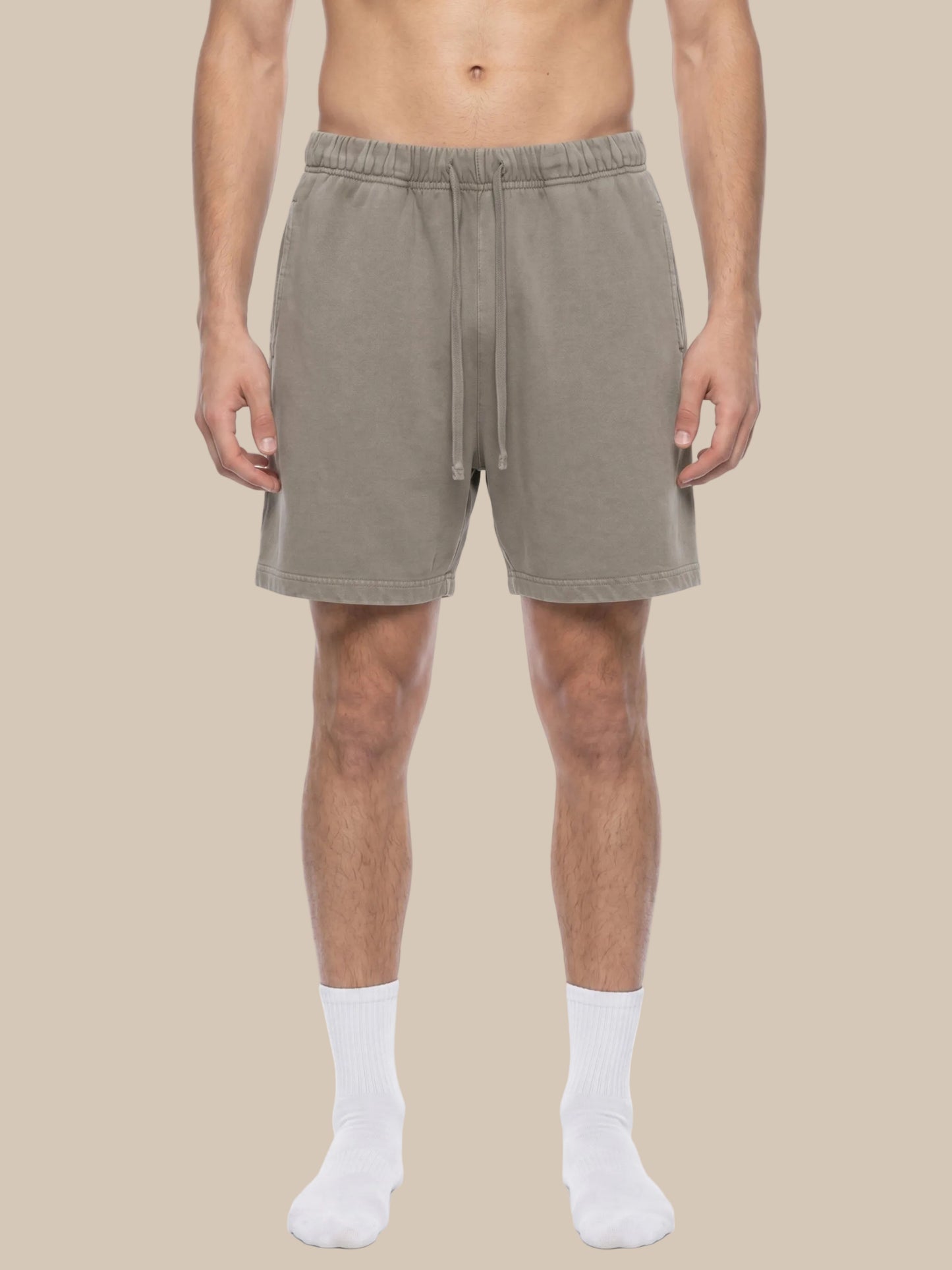 Man wearing beige future-homme vintage wash shorts on a beige  background