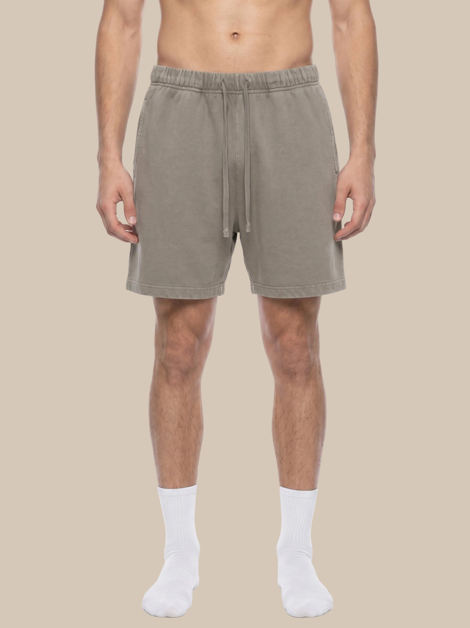 Man wearing beige future-homme vintage wash shorts on a beige  background