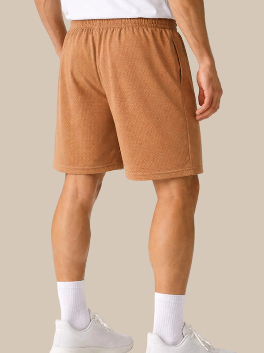 Person wearing brown shorts on a white background