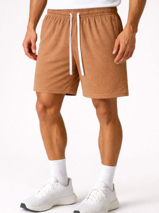 Person wearing brown shorts with a white drawstring on a white background