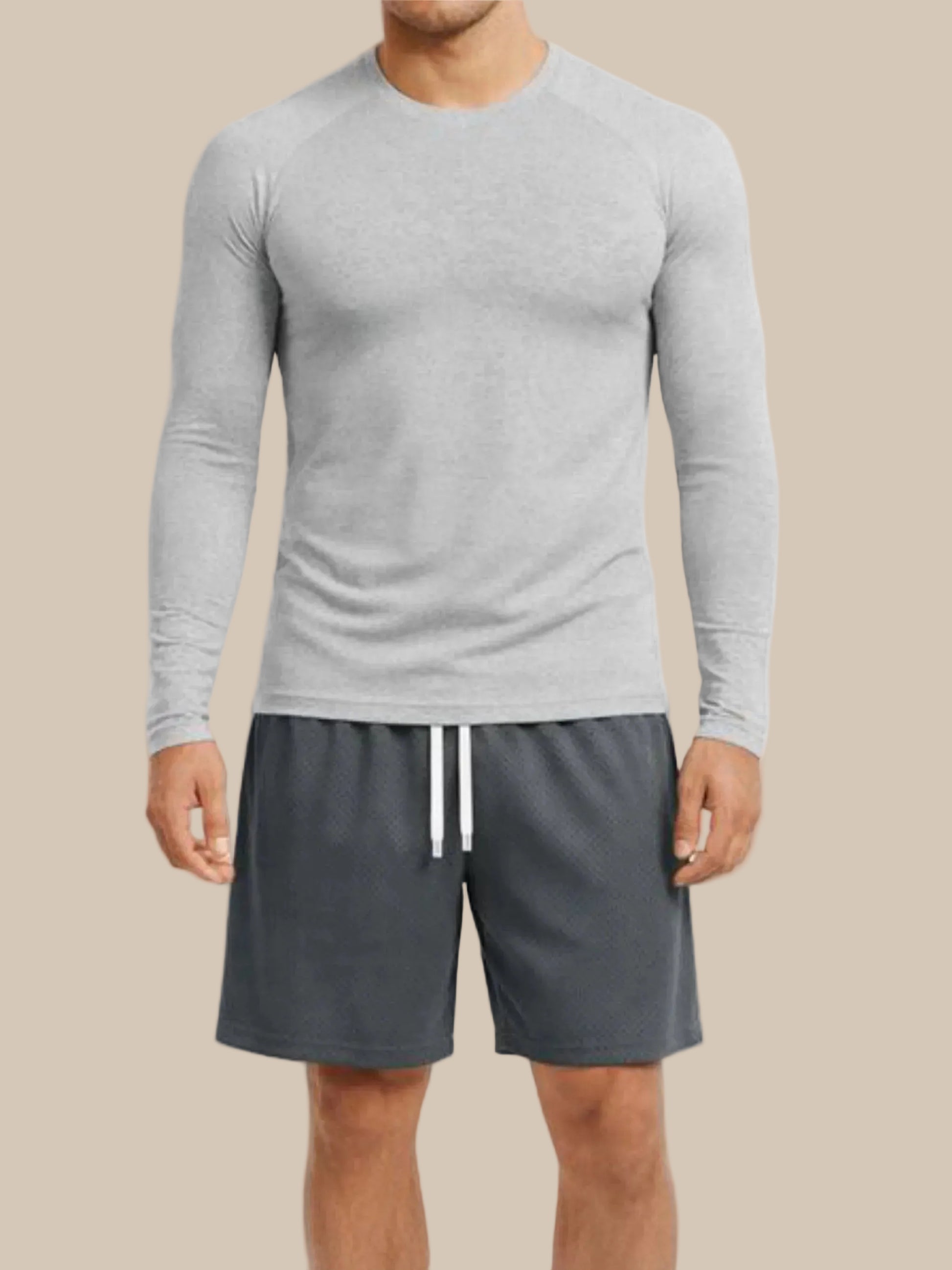 Man wearing a gray long-sleeve shirt and gray shorts on a white background