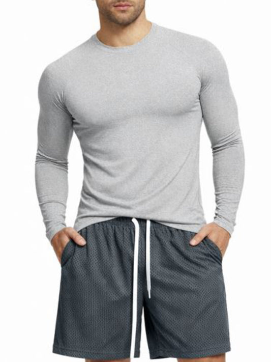 Man wearing a gray long-sleeve shirt and dark shorts on a white background