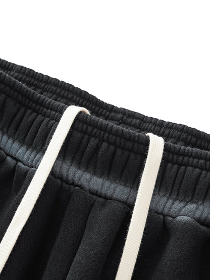 A flat lay of the Future-Homme Ombre Effect Fleece Sweatpants in black front drawstring up close view on a white background.