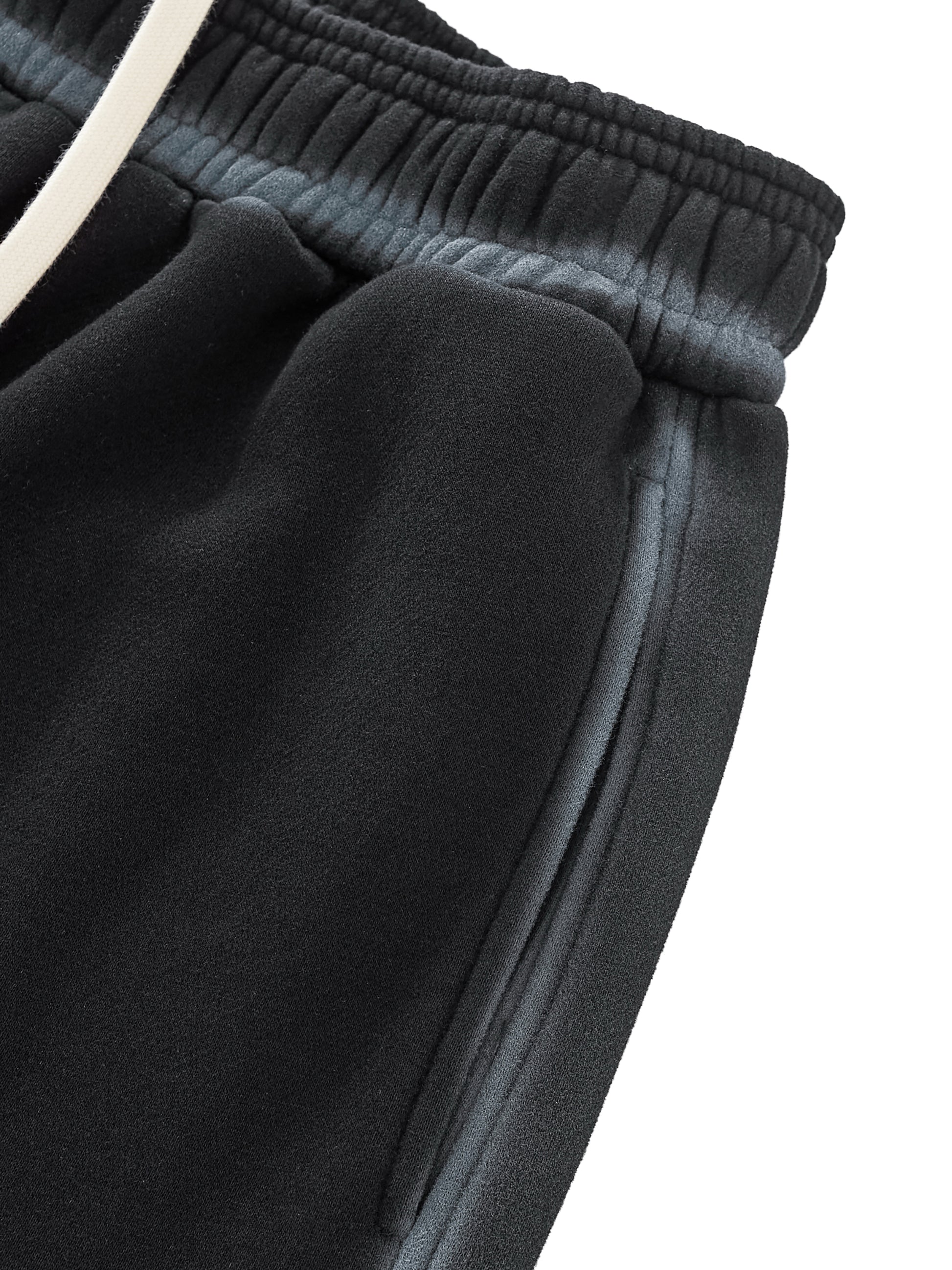 A flat lay of the Future-Homme Ombre Effect Fleece Sweatpants in black front side pocket up close view on a white background.